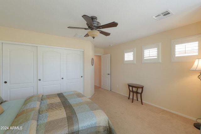 carpeted bedroom with ceiling fan and a closet