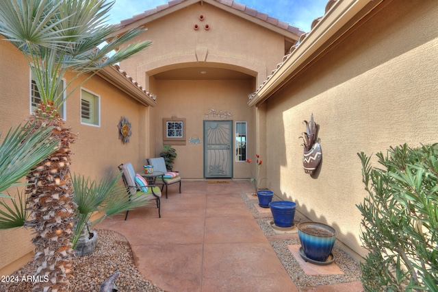 view of exterior entry with a patio area