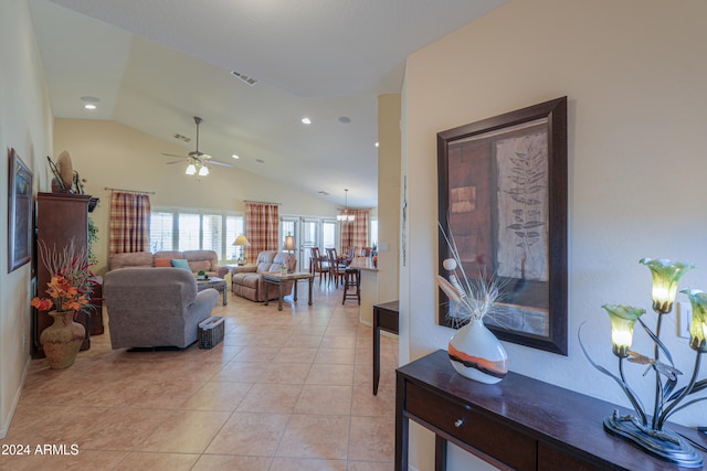 living room featuring ceiling fan, light tile patterned flooring, and vaulted ceiling