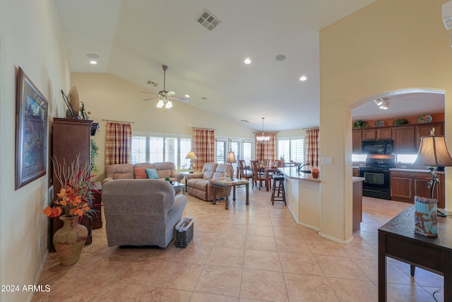 tiled living room featuring ceiling fan and high vaulted ceiling