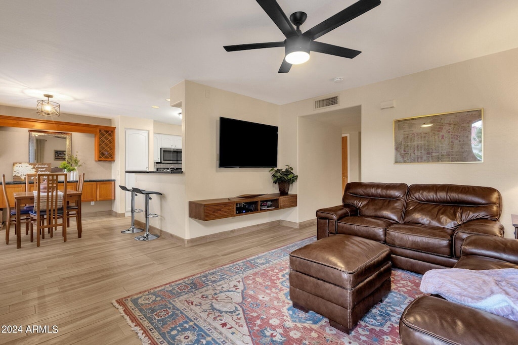 living room with light hardwood / wood-style floors and ceiling fan