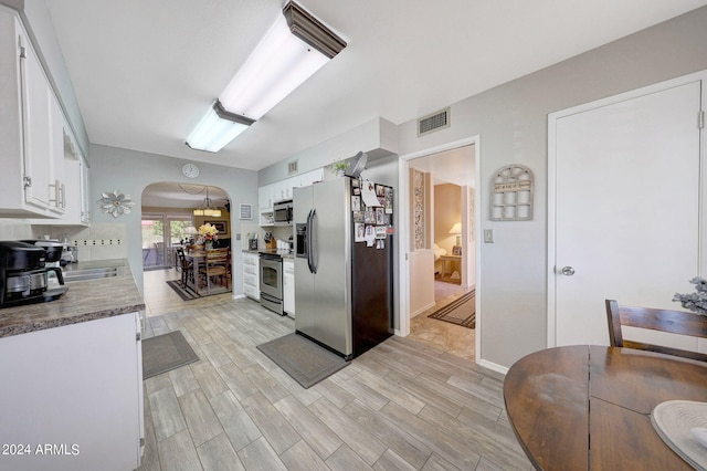 kitchen featuring appliances with stainless steel finishes, white cabinetry, and light wood-type flooring