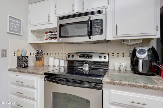 kitchen with appliances with stainless steel finishes, decorative backsplash, and white cabinets