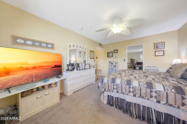 bedroom with a textured ceiling, light colored carpet, and ceiling fan