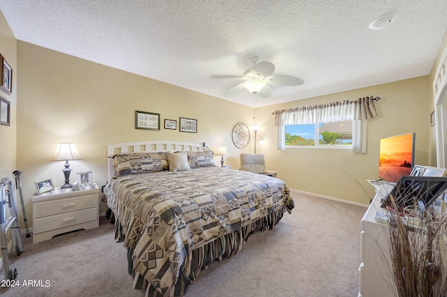 bedroom featuring ceiling fan, a textured ceiling, and light colored carpet