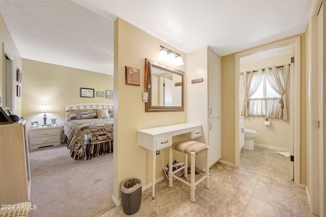 bathroom with toilet, a textured ceiling, and tile patterned floors