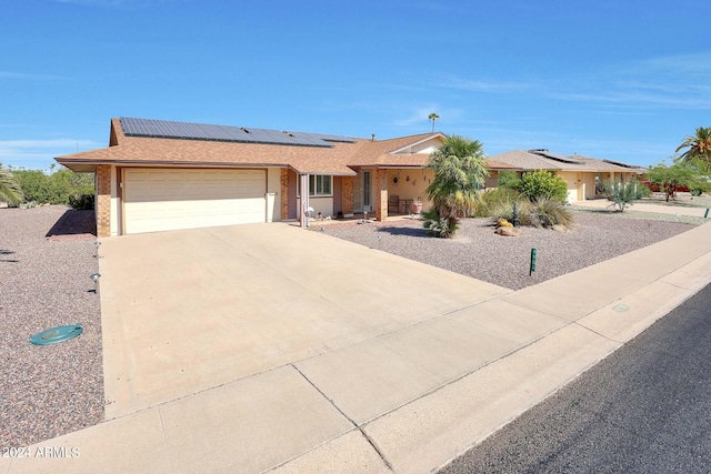 ranch-style home with solar panels and a garage