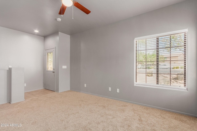 spare room featuring light carpet and ceiling fan