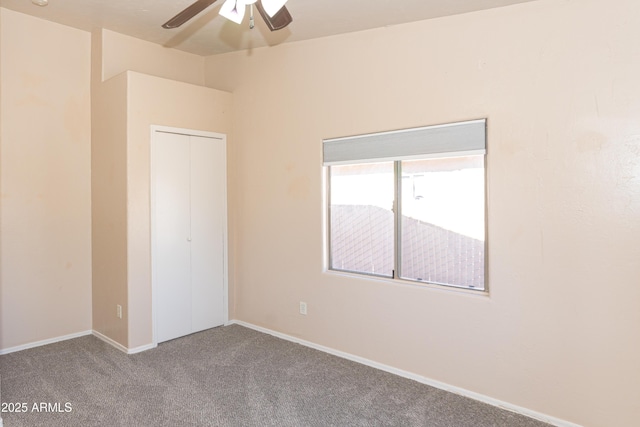 carpeted spare room with ceiling fan