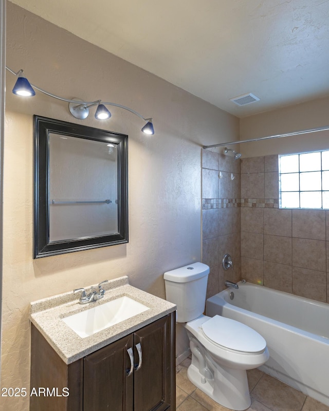 full bathroom with vanity, toilet, tiled shower / bath combo, and tile patterned flooring