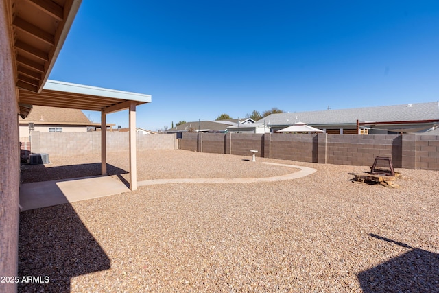 view of yard featuring central AC unit and a fire pit