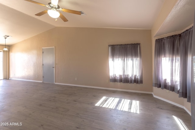 empty room with ceiling fan, wood-type flooring, and vaulted ceiling