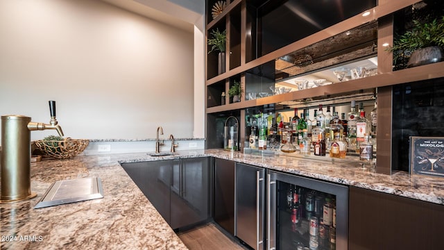 bar featuring wine cooler, refrigerator, light wood-style floors, a community bar, and a sink