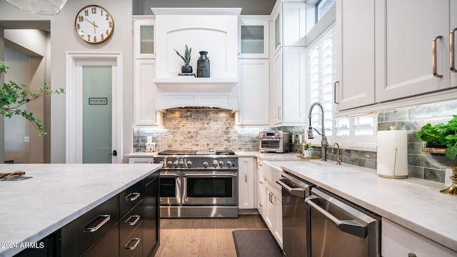 kitchen featuring light countertops, white cabinetry, appliances with stainless steel finishes, and tasteful backsplash