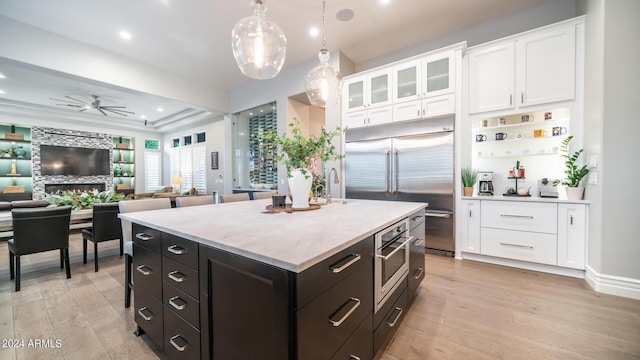 kitchen featuring white cabinetry, ceiling fan, appliances with stainless steel finishes, and light wood finished floors