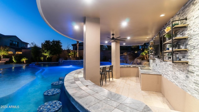 pool featuring an outdoor bar, a patio, and area for grilling