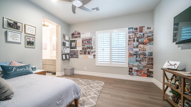 bedroom with a ceiling fan, baseboards, wood finished floors, ensuite bathroom, and visible vents