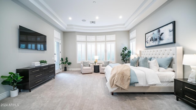 bedroom with a raised ceiling, baseboards, visible vents, and light colored carpet