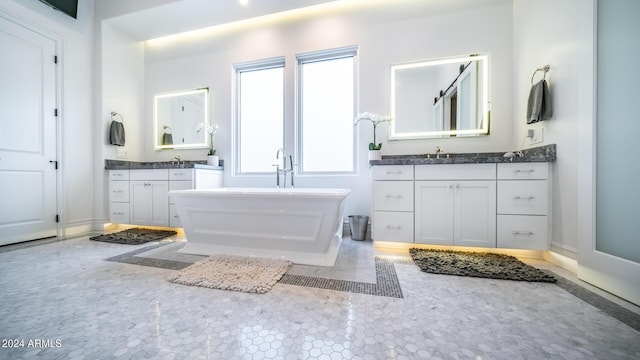 full bathroom featuring a soaking tub, two vanities, and a sink