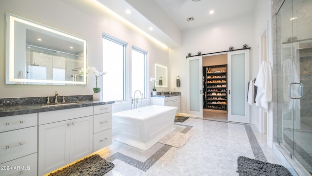 bathroom with visible vents, a stall shower, two vanities, a sink, and recessed lighting
