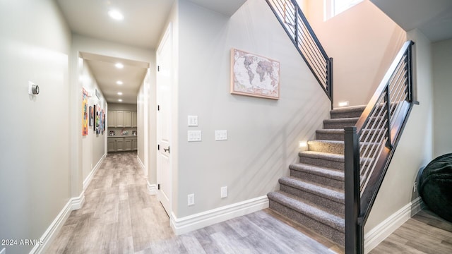 stairs with recessed lighting, baseboards, and wood finished floors