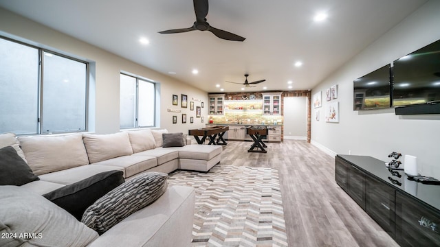 living area with baseboards, ceiling fan, recessed lighting, and light wood-style flooring