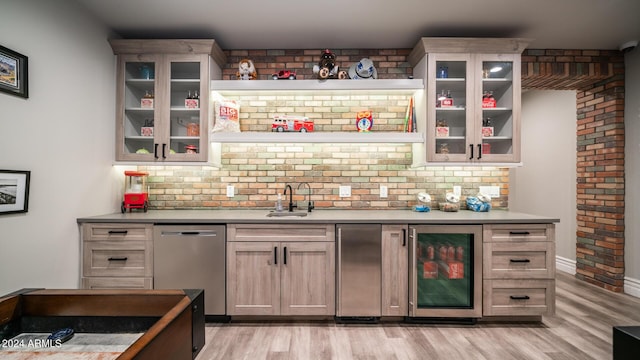 bar with stainless steel dishwasher, wine cooler, a sink, light wood-style flooring, and wet bar