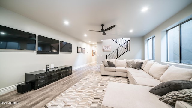 living area with ceiling fan, recessed lighting, baseboards, wood finished floors, and stairway