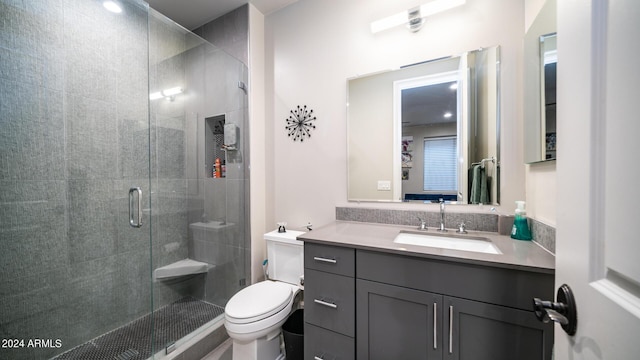 bathroom featuring vanity, toilet, and a shower stall