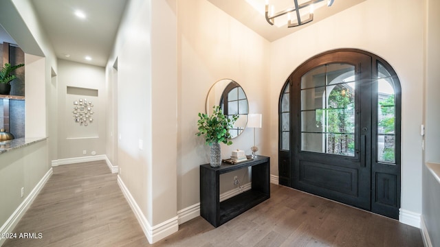 entryway with recessed lighting, baseboards, an inviting chandelier, and light wood finished floors