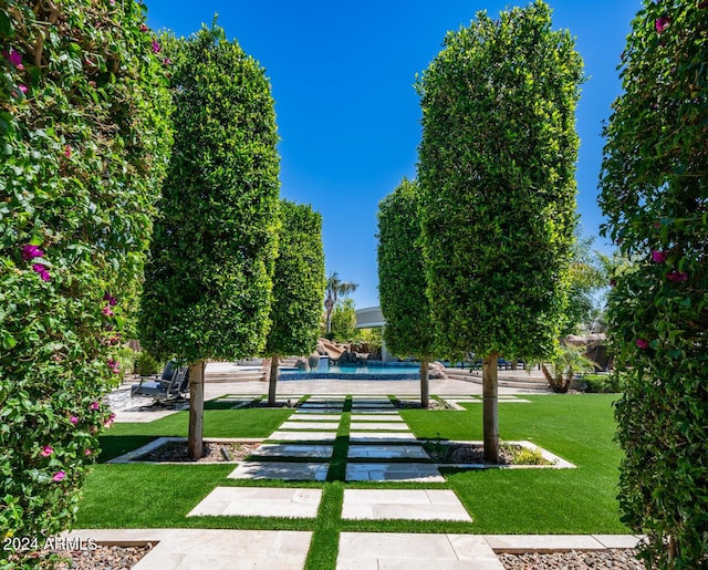 view of home's community featuring a lawn and a pool
