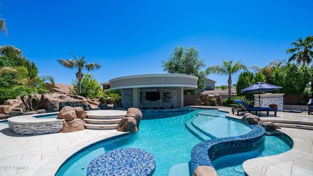 view of swimming pool with a pool with connected hot tub and a patio area