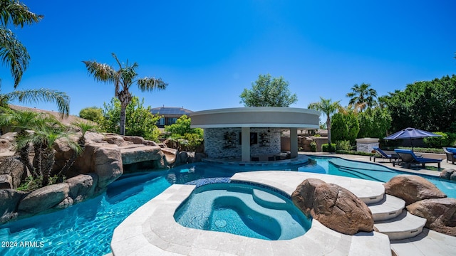 pool with an in ground hot tub and a patio area