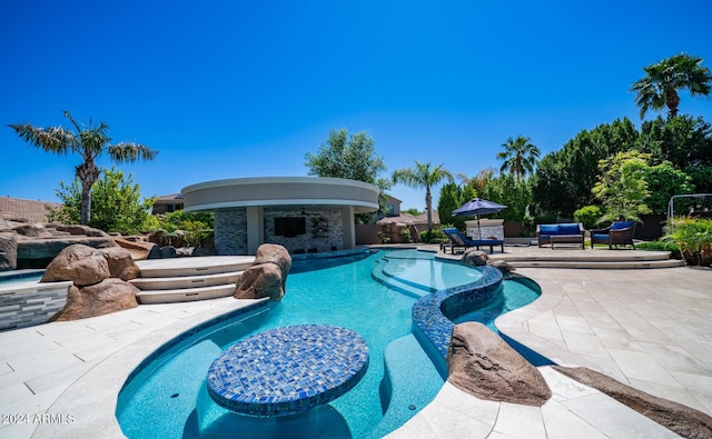 view of pool featuring a patio, a pool with connected hot tub, and outdoor lounge area