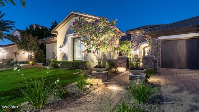 view of front of house with a garage, stone siding, decorative driveway, stucco siding, and a tile roof