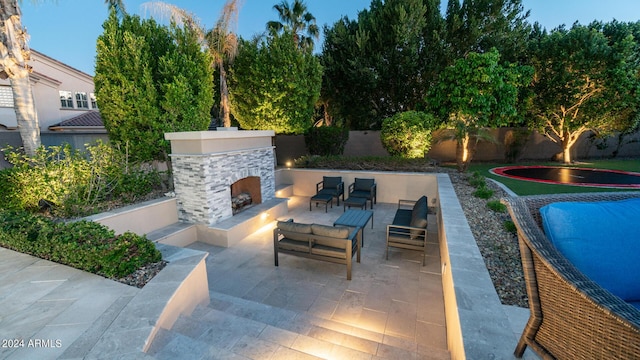 view of patio / terrace with a fenced backyard and an outdoor living space with a fireplace