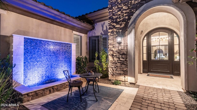 entrance to property featuring stucco siding and stone siding