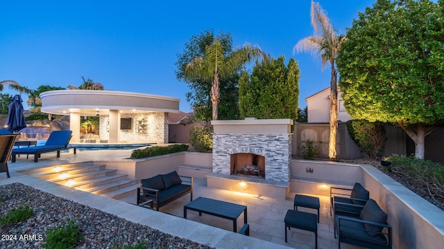 view of patio with a fenced backyard and an outdoor living space with a fireplace
