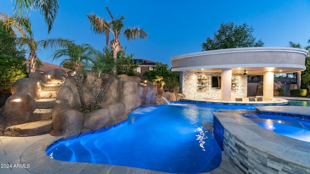 outdoor pool with an in ground hot tub, a patio area, and ceiling fan
