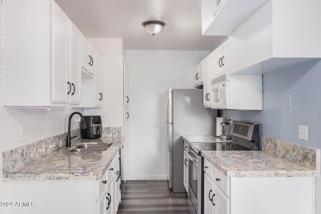 kitchen with stainless steel electric range oven, sink, dark hardwood / wood-style flooring, and white cabinetry