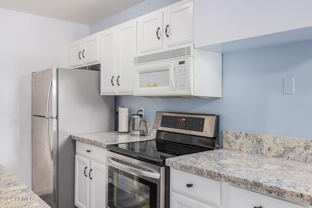 5921 W Golden Ln, Glendale, AZ 85302 - kitchen featuring white cabinets, light stone countertops, and stainless steel appliances
