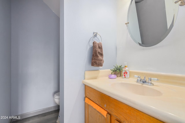 bathroom with hardwood / wood-style floors, vanity, and toilet