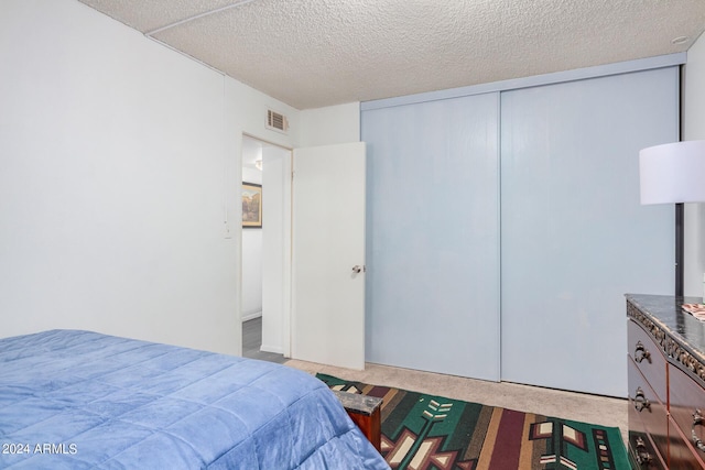 5921 W Golden Ln, Glendale, AZ 85302 - bedroom with visible vents, a textured ceiling, and a closet