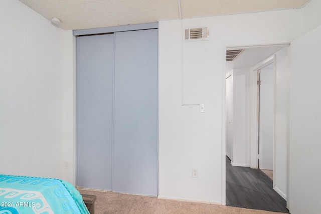 bedroom featuring a closet, hardwood / wood-style floors, and a textured ceiling