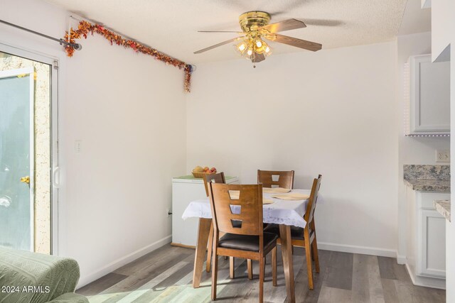 dining area with ceiling fan, a textured ceiling, and light hardwood / wood-style floors