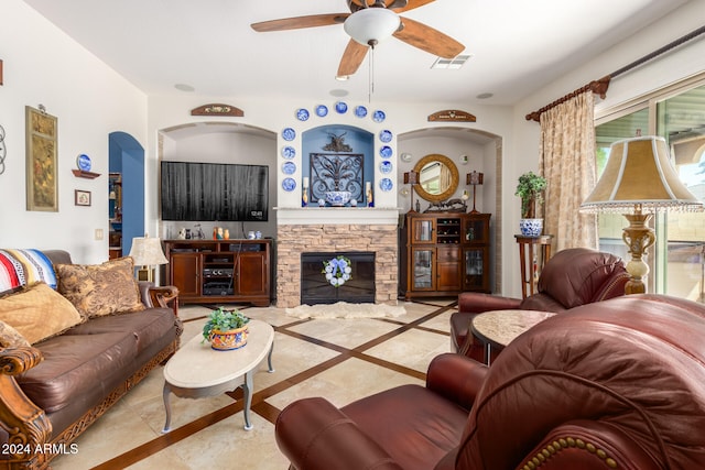 living room featuring ceiling fan and a fireplace