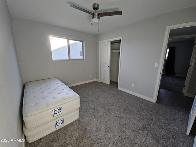 unfurnished bedroom featuring ceiling fan, a closet, and dark carpet