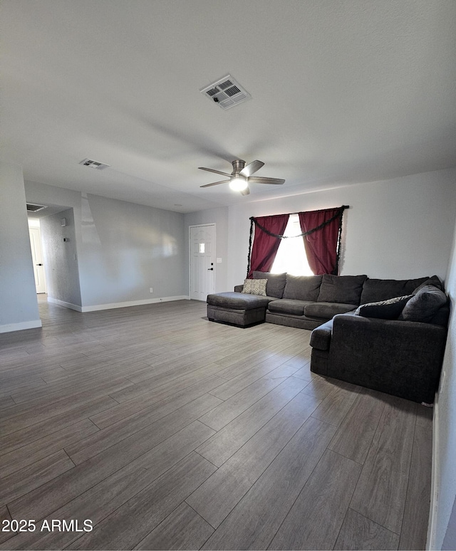 living room with wood finished floors, visible vents, and baseboards