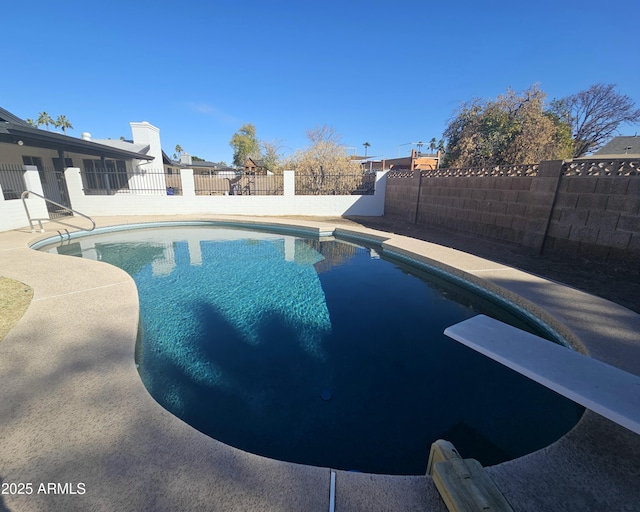 view of pool with a diving board