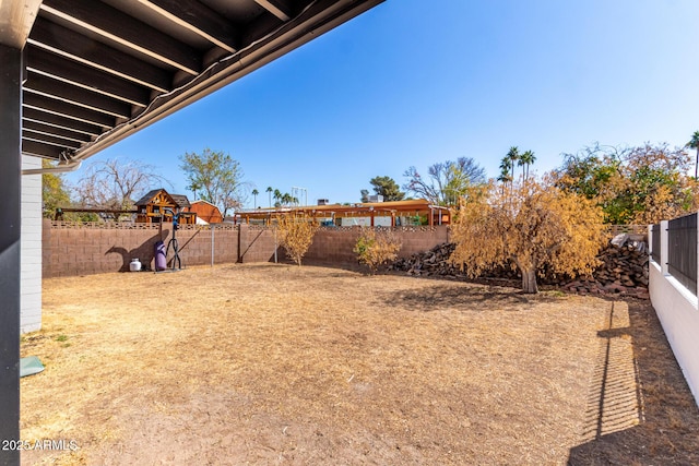 view of yard featuring fence and a playground